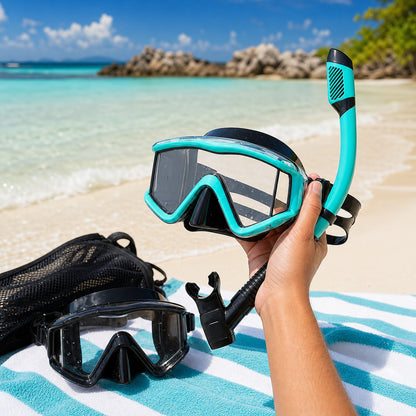 Aqua panoramic snorkel mask and dry-top snorkel held on a sunny beach with black set and mesh bag nearby